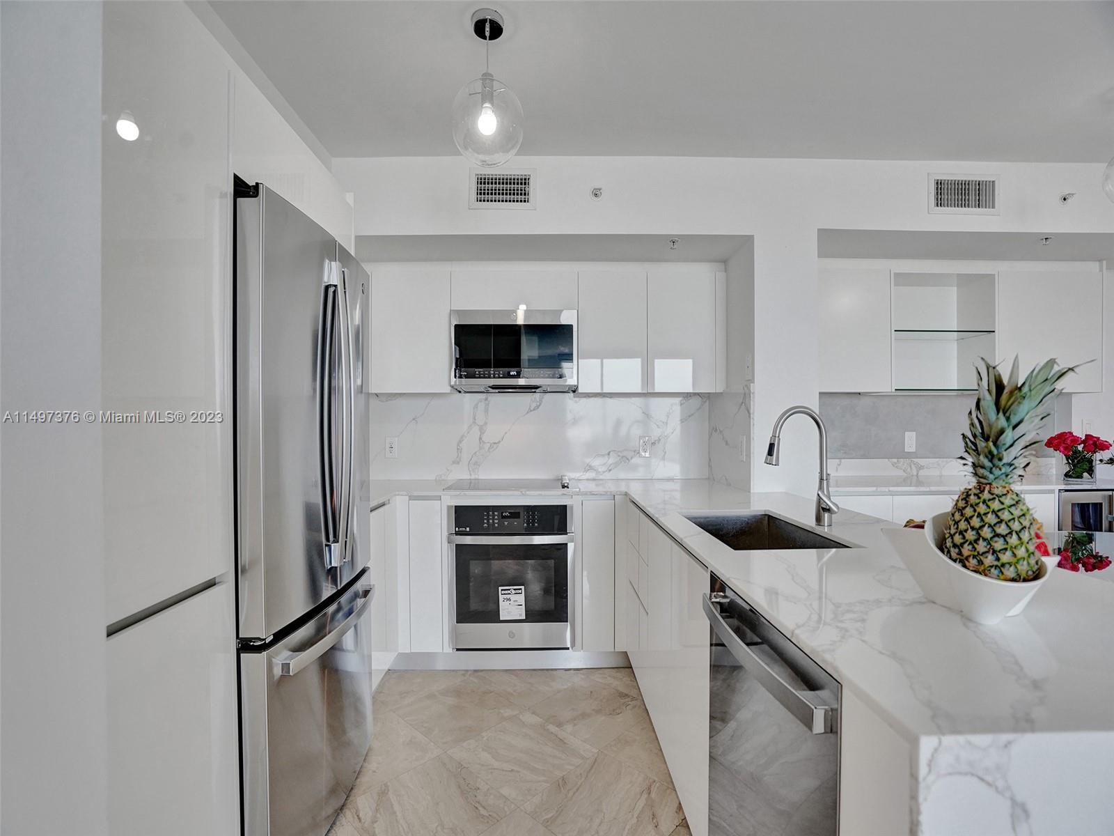 90 Alton Road, Unit 1109 Miami Beach, FL 33139 - Photo 5 of 23 a kitchen with stainless steel appliances granite countertop a sink a stove and a refrigerator
