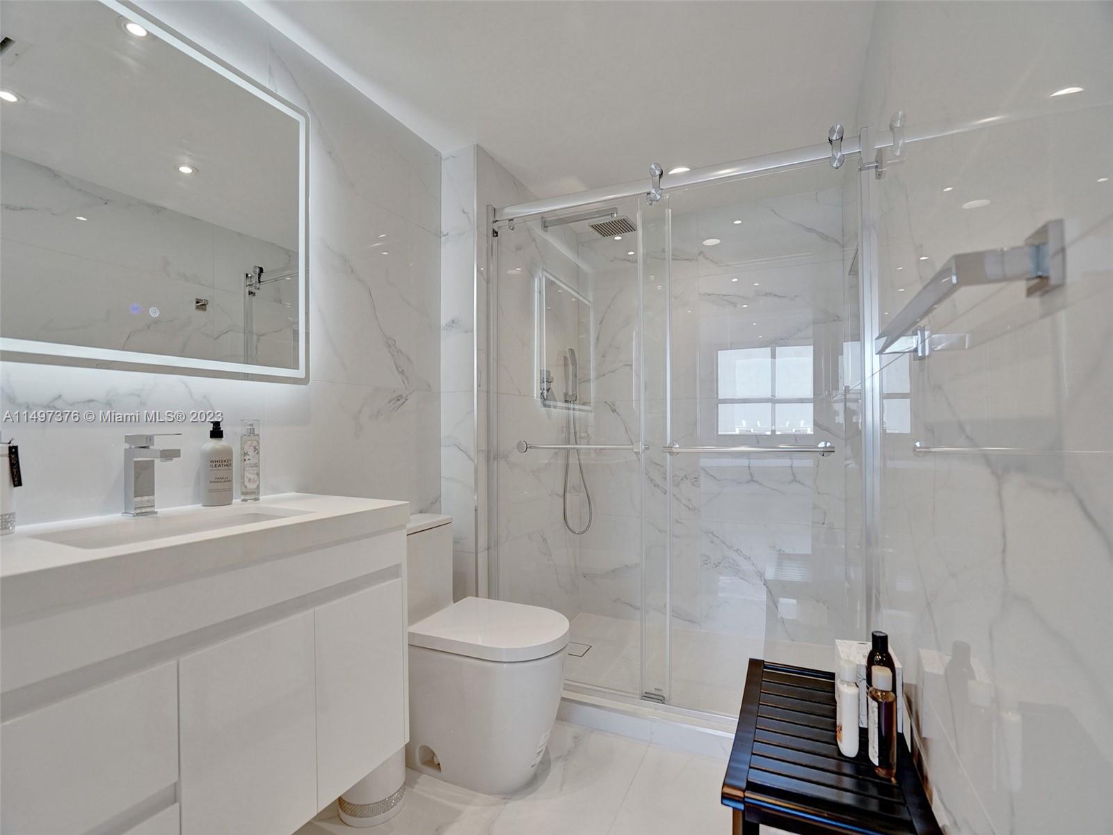 90 Alton Road, Unit 1109 Miami Beach, FL 33139 - Photo 8 of 23 a bathroom with a toilet a sink a mirror and shower