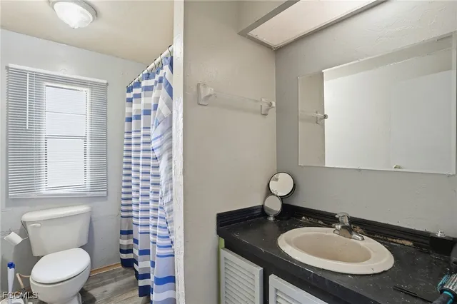 a bathroom with a granite countertop sink a toilet and a mirror