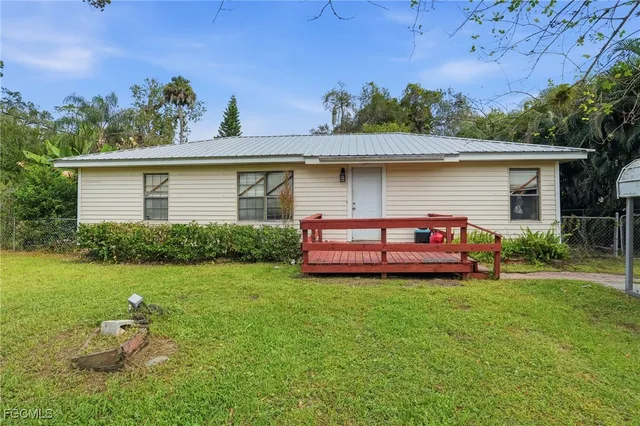 a view of a house with a yard and sitting area