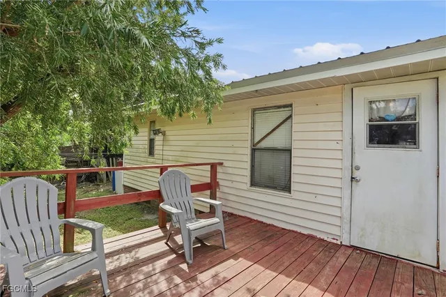 a balcony with table and chairs and wooden floor
