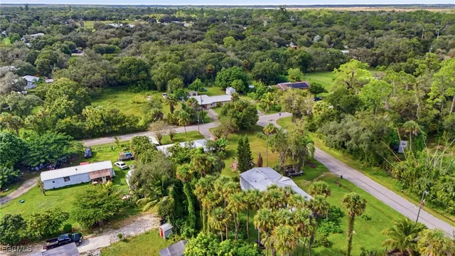 an aerial view of residential house with outdoor space and trees all around
