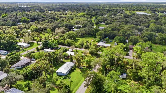 an aerial view of residential house with outdoor space and trees all around