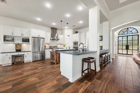 a kitchen with stainless steel appliances granite countertop a sink stove and refrigerator