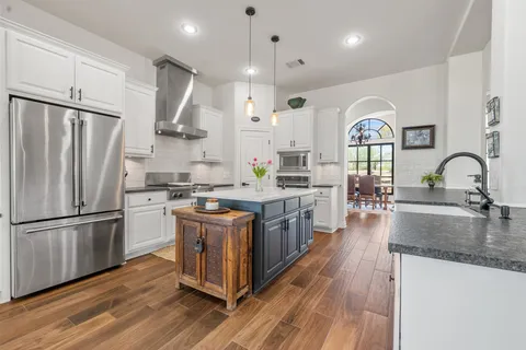 a kitchen with stainless steel appliances granite countertop a sink stove and refrigerator