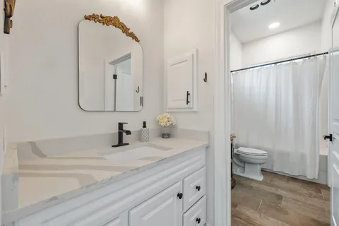 a bathroom with a toilet sink and mirror