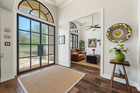 a living room with furniture a bookshelf and a large window