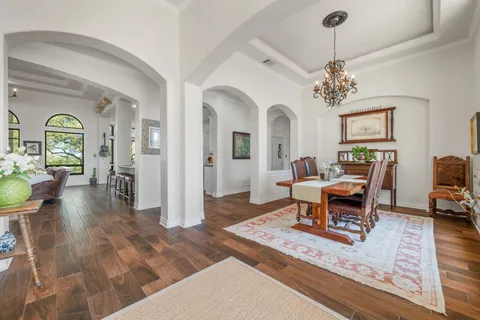 a living room with furniture chandelier and a large window