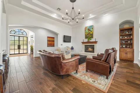 a living room with furniture a flat screen tv and kitchen view