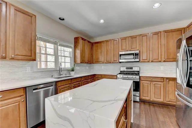 a kitchen with stainless steel appliances granite countertop a sink stove microwave and cabinets
