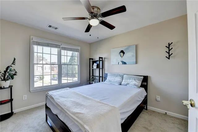 a bedroom with a large bed and a chandelier fan