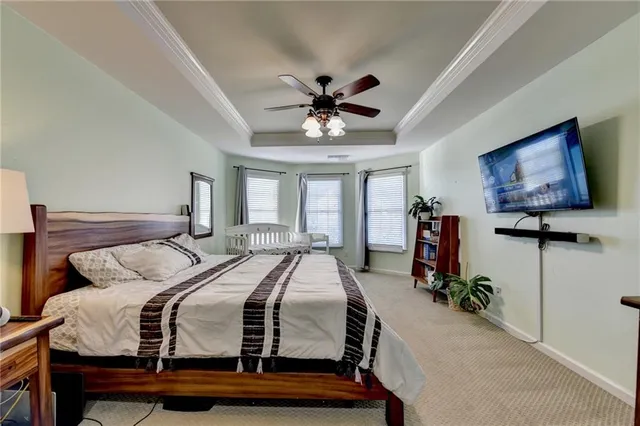 a bedroom with bed tv and a window