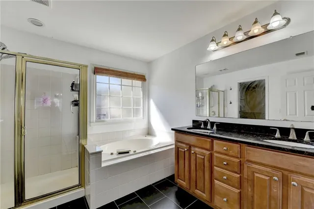 a bathroom with a granite countertop sink mirror and a bathtub
