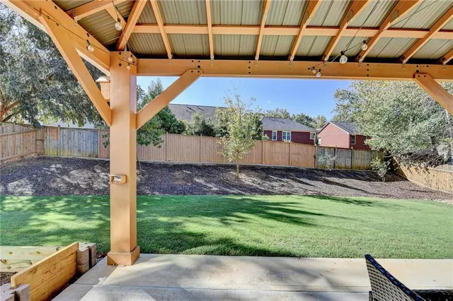 a view of a backyard with table and chairs under an umbrella
