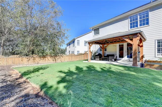 a view of a house with backyard and sitting area