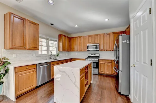 a kitchen with stainless steel appliances granite countertop a stove a sink dishwasher and a refrigerator