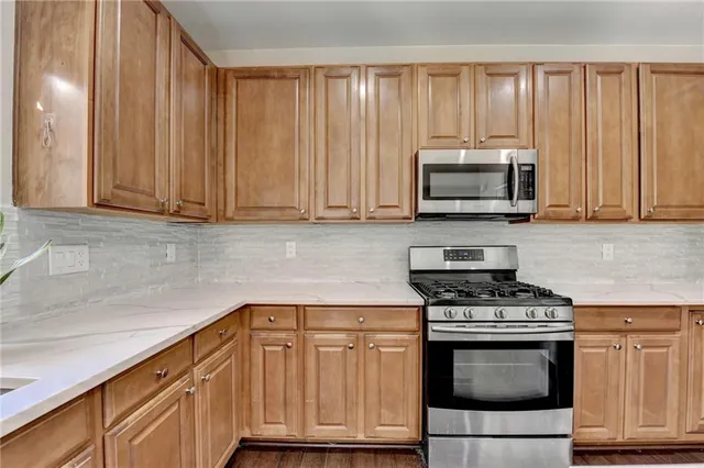 a kitchen with granite countertop wooden cabinets and stainless steel appliances