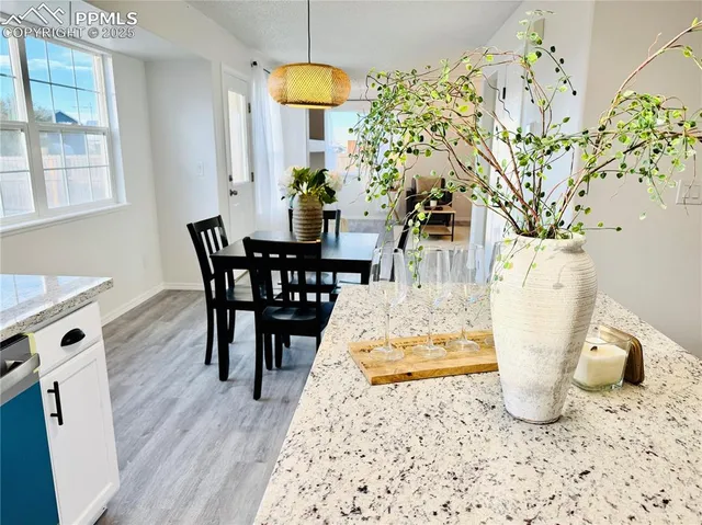 a kitchen with a sink a stove top oven and wooden floors