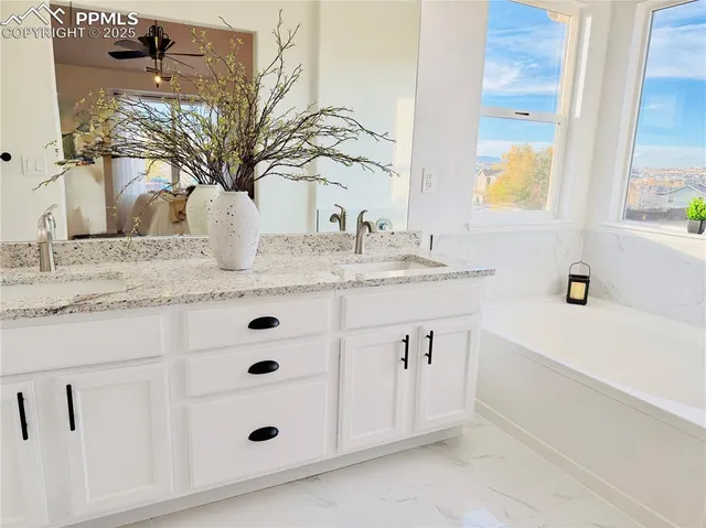 a bathroom with a granite countertop sink a mirror and shower
