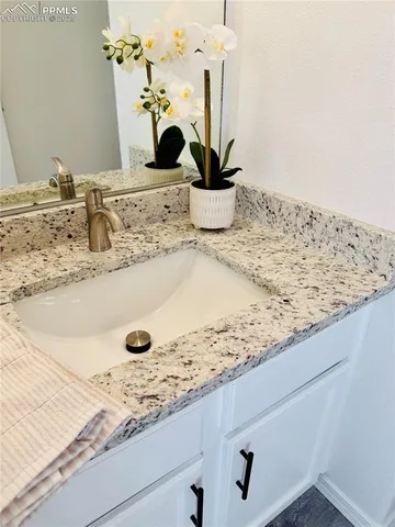 a bathroom with a granite countertop sink and a mirror