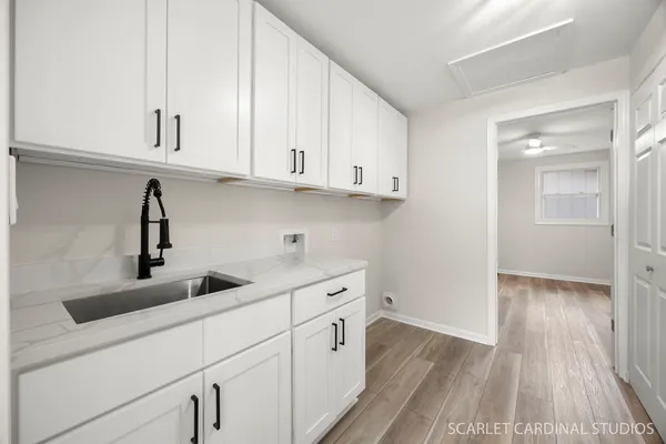 a kitchen with white cabinets and sink