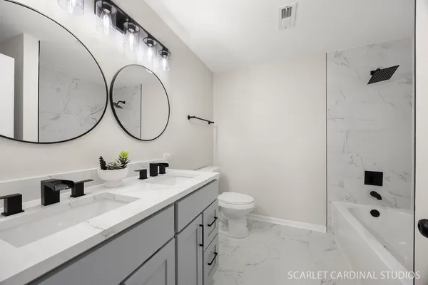 a bathroom with a double vanity sink mirror and toilet