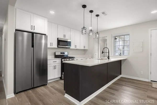 a kitchen with stainless steel appliances granite countertop a refrigerator and a sink