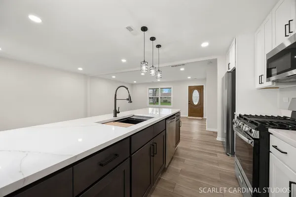 a kitchen with stainless steel appliances a sink stove and cabinets