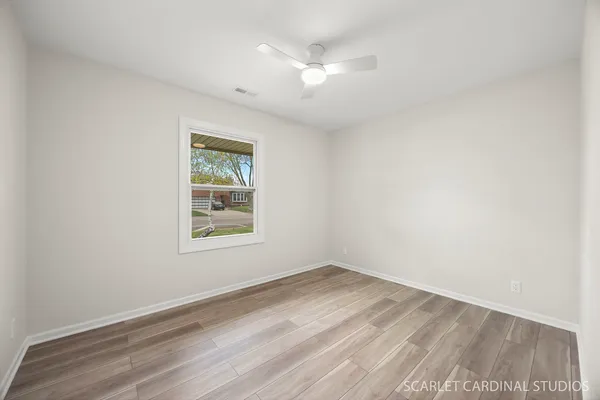 an empty room with a window and a ceiling fan
