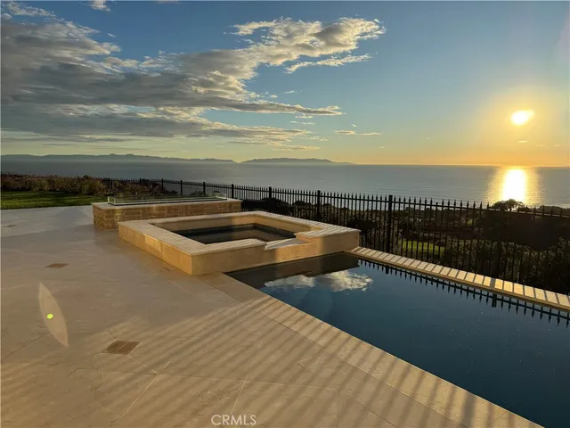a view of swimming pool with outdoor seating and ocean view