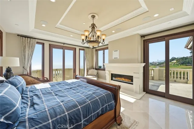 a spacious bedroom with a large bed and a chandelier