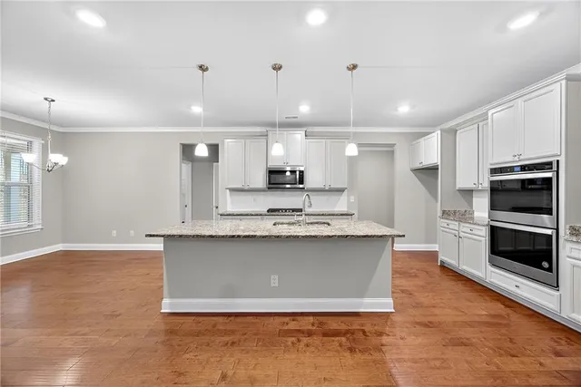 a view of kitchen with sink microwave and cabinets