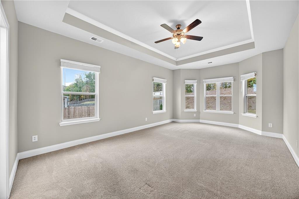 220 Calebee Avenue Senoia, GA 30276 - Photo 18 of 47 an empty room with ceiling fan and windows
