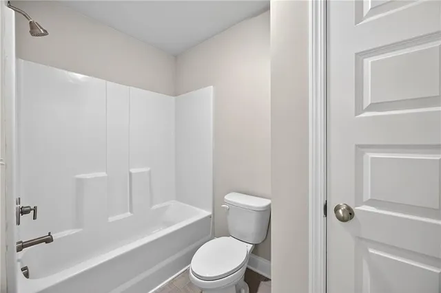 a white toilet sitting next to a bath tub