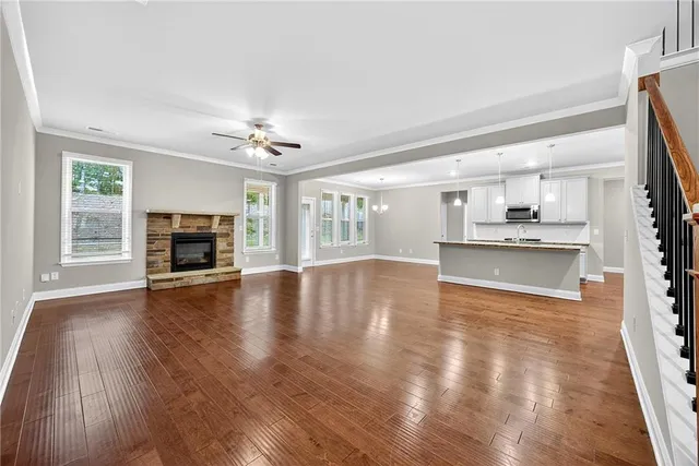 a view of an empty room with wooden floor and a fireplace