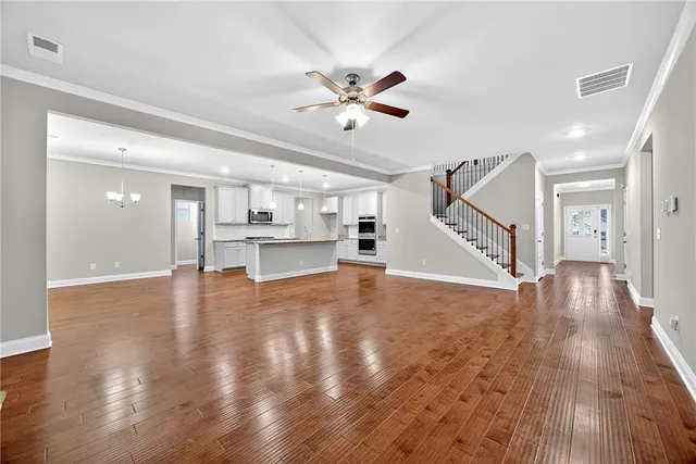 a view of empty room with wooden floor and ceiling fan