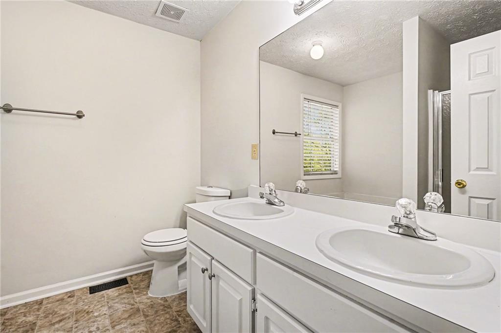 4083 Country Lane Gainesville, GA 30507 - Photo 14 of 18 a bathroom with a sink a toilet and mirror
