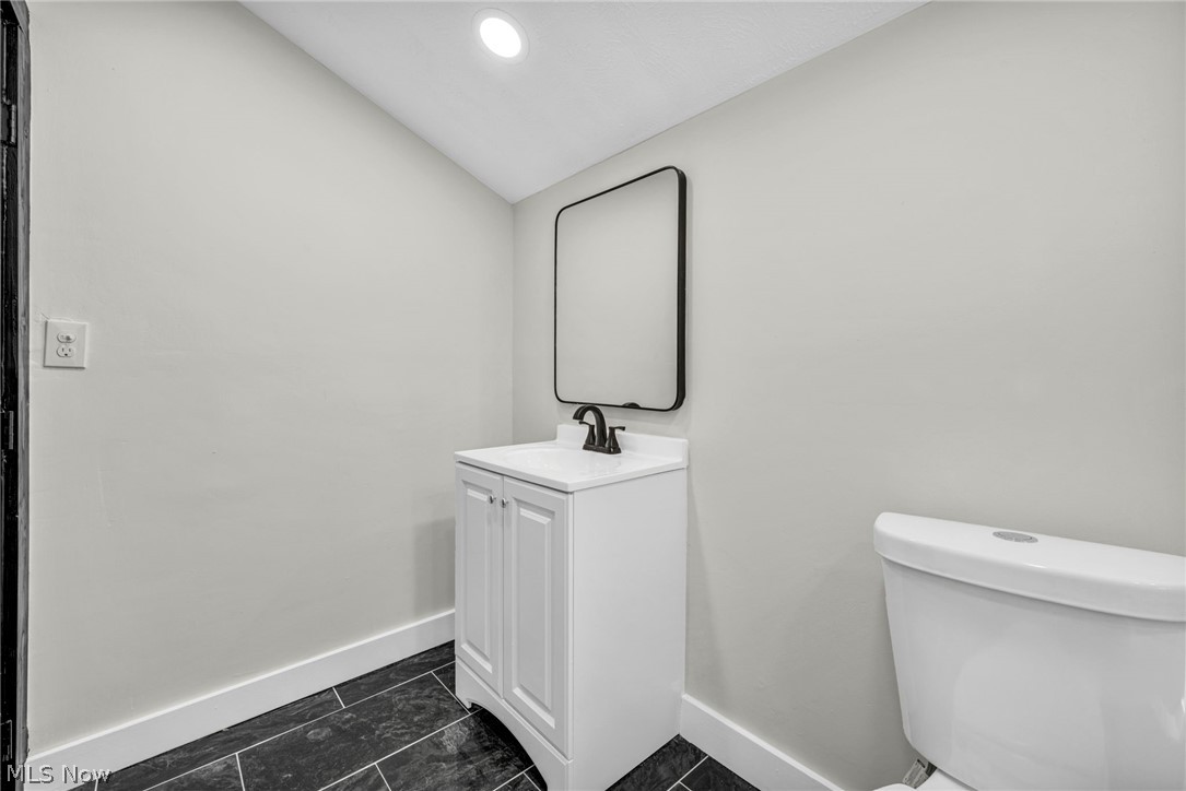 7339 River Road Olmsted Falls, OH 44138 - Photo 24 of 45 Bathroom featuring a white vanity with integrated sink, matte black faucet, and a black-framed rectangular mirror