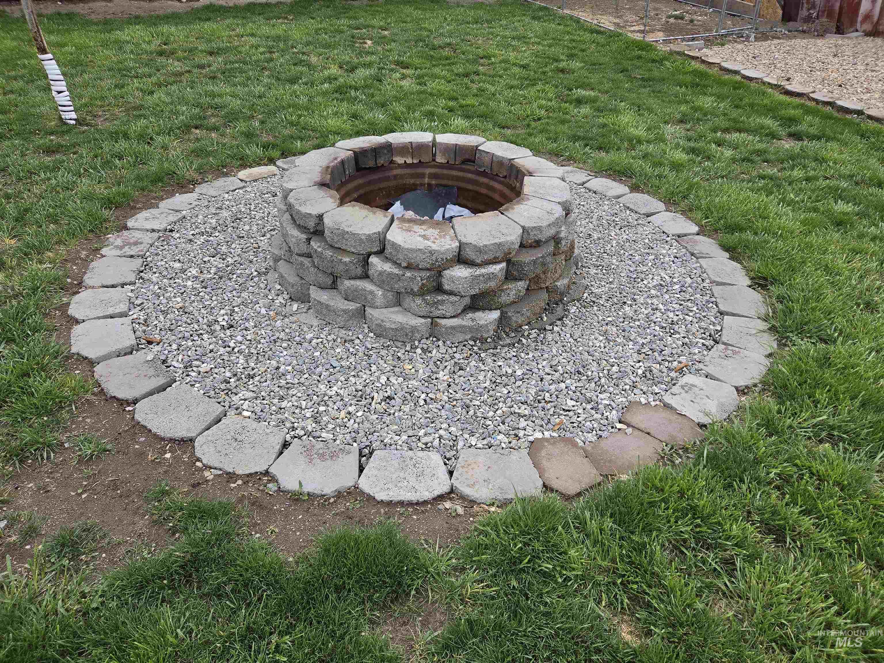 905 15th Drive Rupert, ID 83350 - Photo 17 of 20 Stone-lined fire pit with a gravel base, set within a grass area