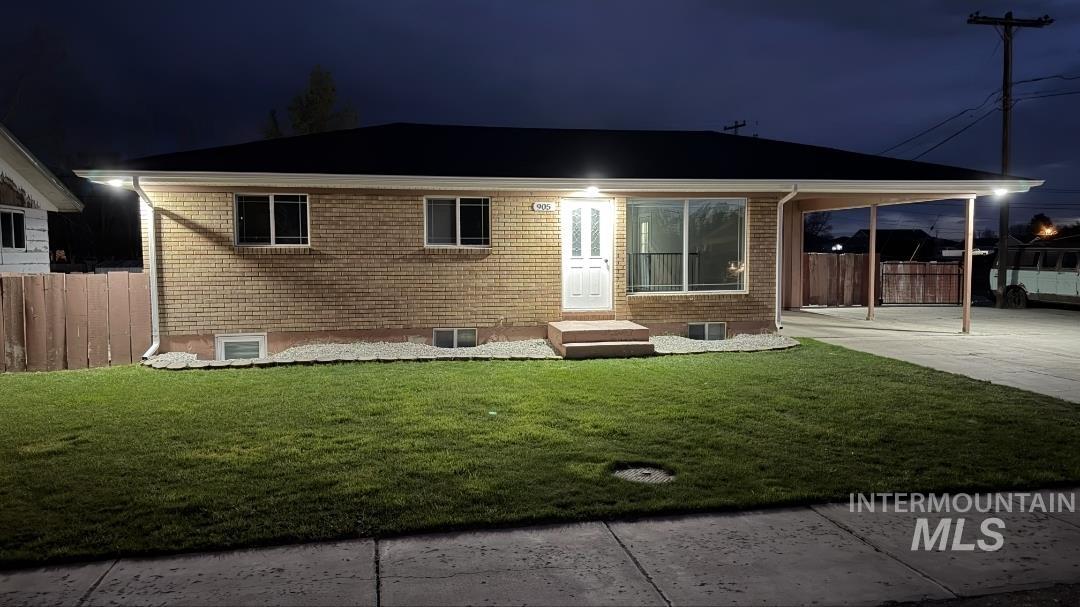 905 15th Drive Rupert, ID 83350 - Photo 19 of 20 Brick exterior with a covered carport, expansive front lawn, and mature landscaping