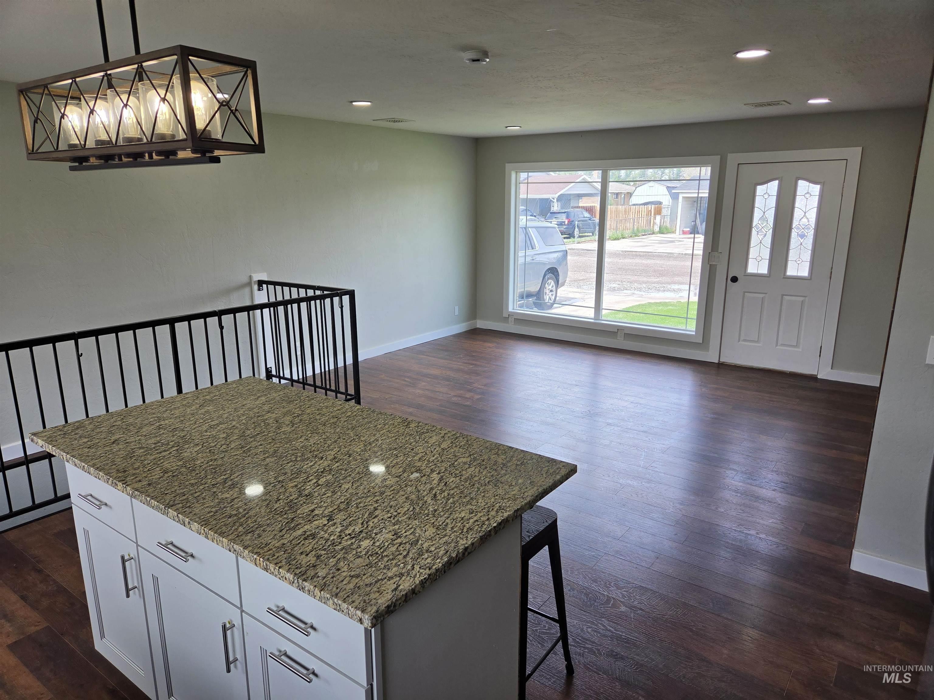 905 15th Drive Rupert, ID 83350 - Photo 3 of 20 Kitchen island with light-toned countertop, wood-finish flooring, recessed lighting, and a decorative chandelier