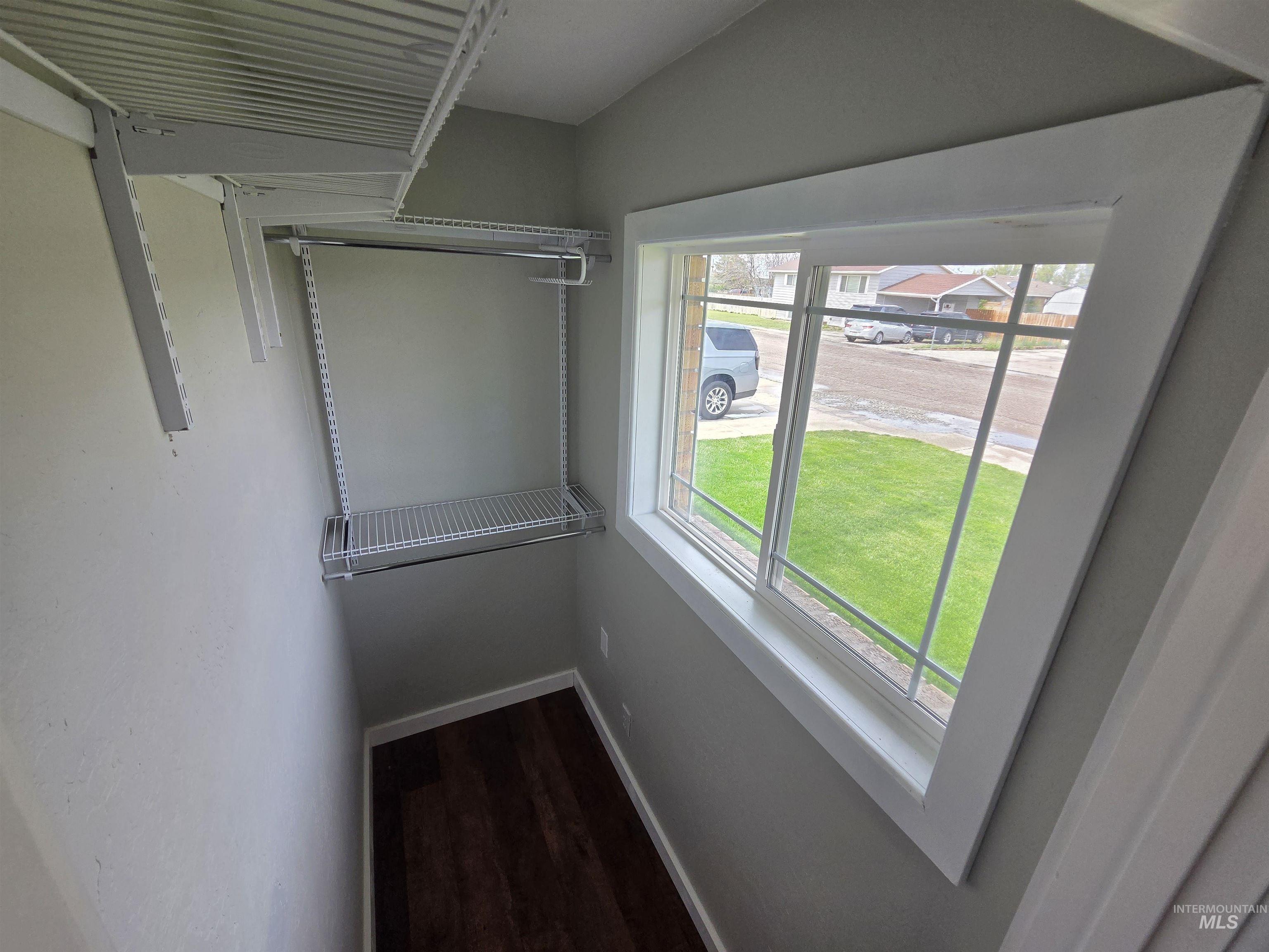 905 15th Drive Rupert, ID 83350 - Photo 10 of 20 Walk-in closet featuring wire shelving, hanging rods, an exterior window, and wood-finish flooring