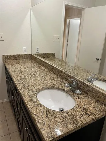 a bathroom with a granite countertop sink and a granite counter tops