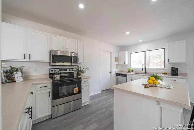 a kitchen with a sink appliances and cabinets