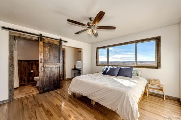 a bedroom with a bed and a large window