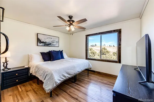 a bedroom with a bed a window and a flat screen television