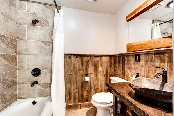 a bathroom with a sink a toilet a mirror and shower