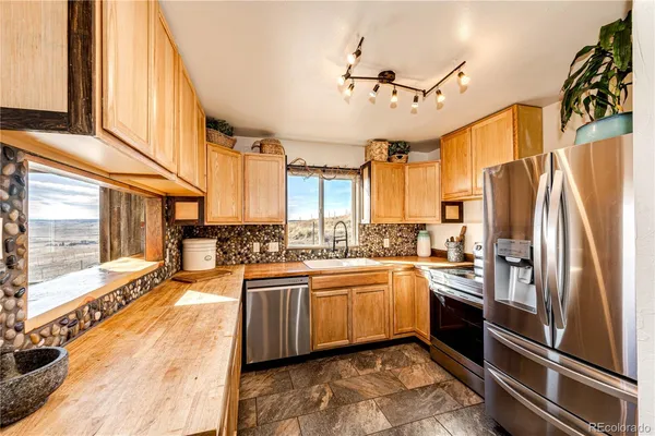 a very nice looking kitchen with a large window appliances and cabinets