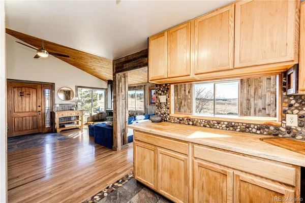 a open kitchen with stainless steel appliances granite countertop a refrigerator a sink dishwasher a stove and white countertops with wooden floor