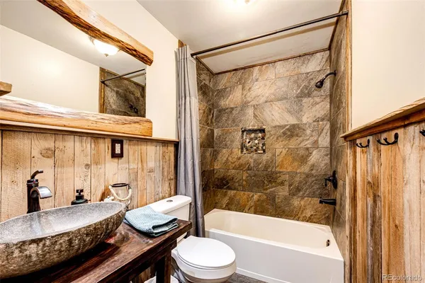 a bathroom with a granite countertop sink toilet and shower